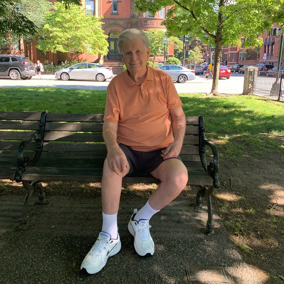 Brian Wilson sitting on a park bench.