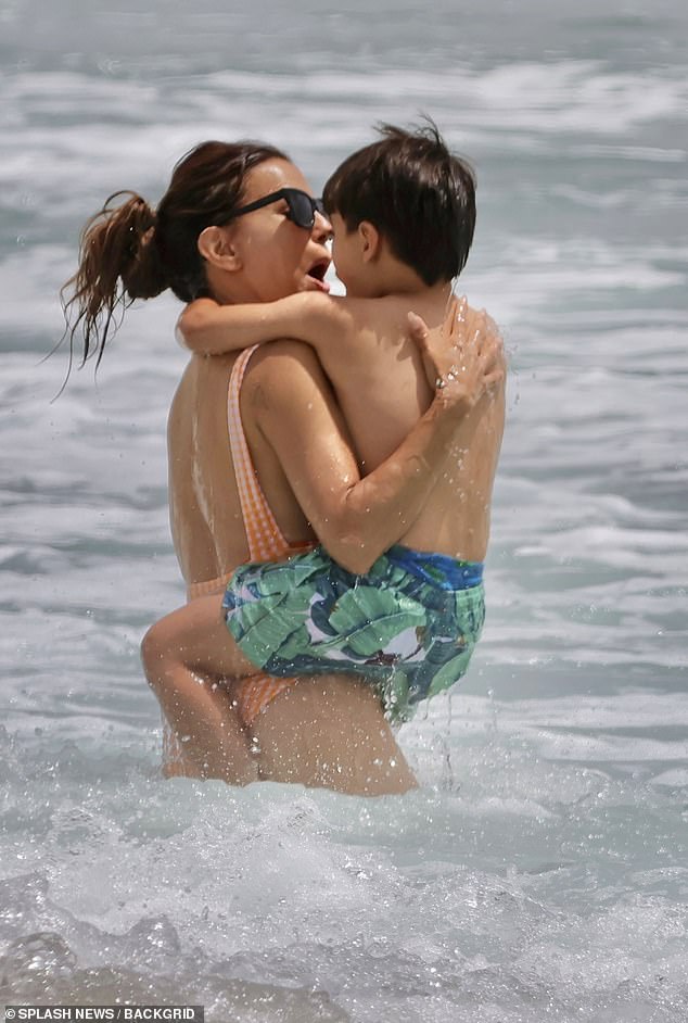 The actress held her son close as she ventured into the water
