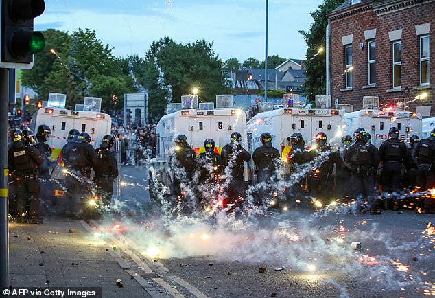 Fireworks thrown at riot police illluminate the road during a third night of demonstrations in Ballymena