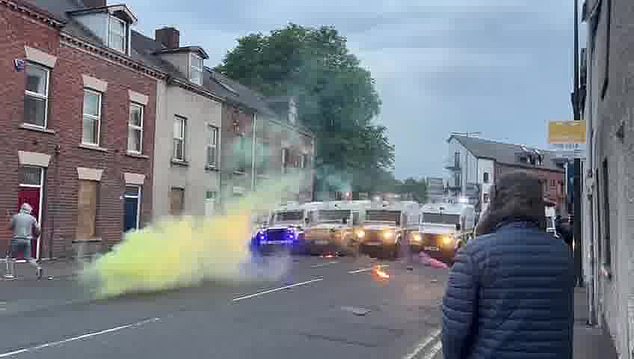 A young female youth throws item at police vehicles on the third day of unrest in Ballymena