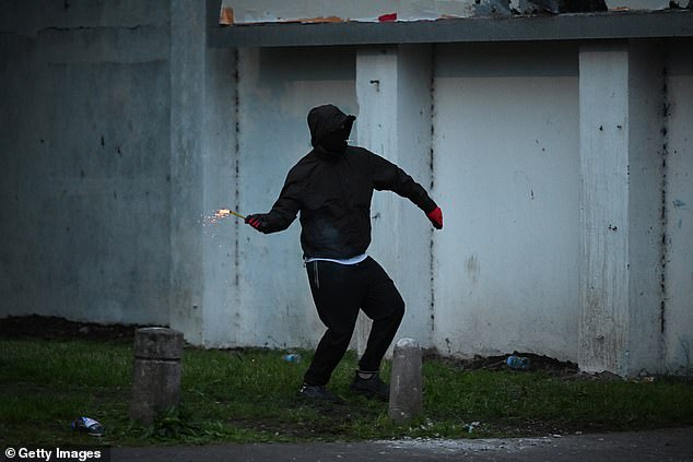 A member of the crowd throws an object towards the PSNI riot squad officers