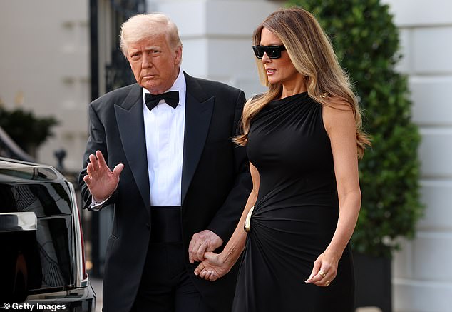 President Donald Trump (left) holds onto first lady Melania Trump's (right) hand as they exit the White House and travel to the Kennedy Center Wednesday night
