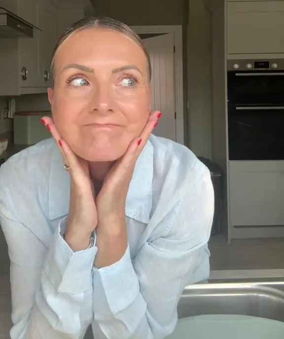 Woman in her 50s, pregnant, expressing a pensive look.