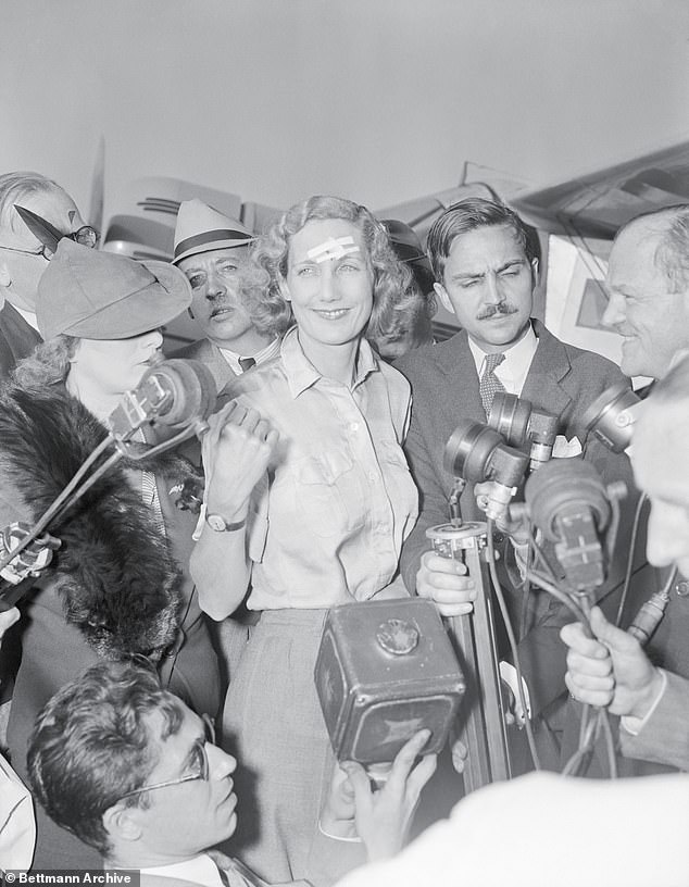 Beryl Markham, with adhesive tape covering the slight cut she received in setting her plane down in Nova Scotia Bog, speaking to the press on her arrival at Floyd Bennett Field in New York City