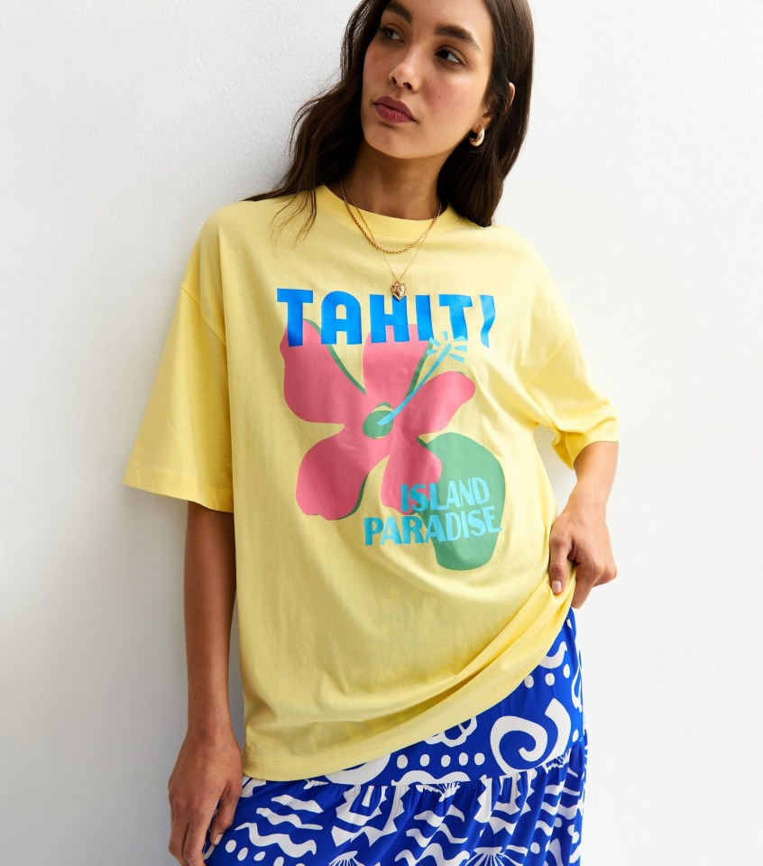 Woman wearing a yellow Tahiti-print t-shirt.