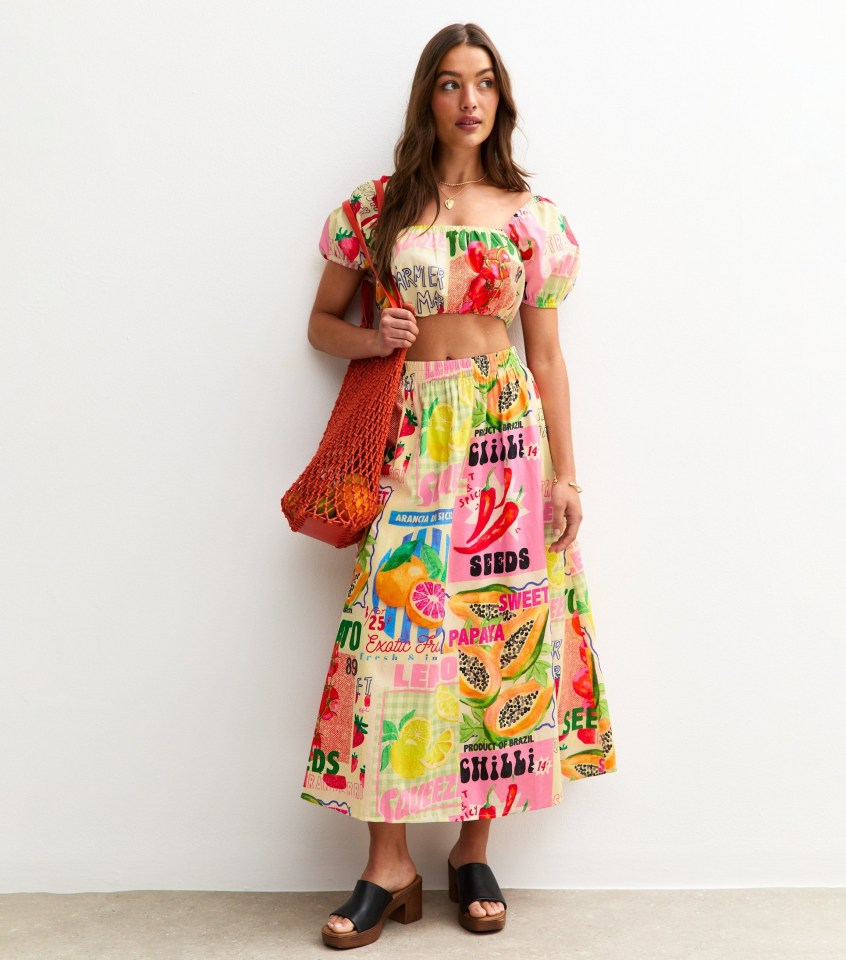 Model wearing a fruit-print crop top and midi skirt.