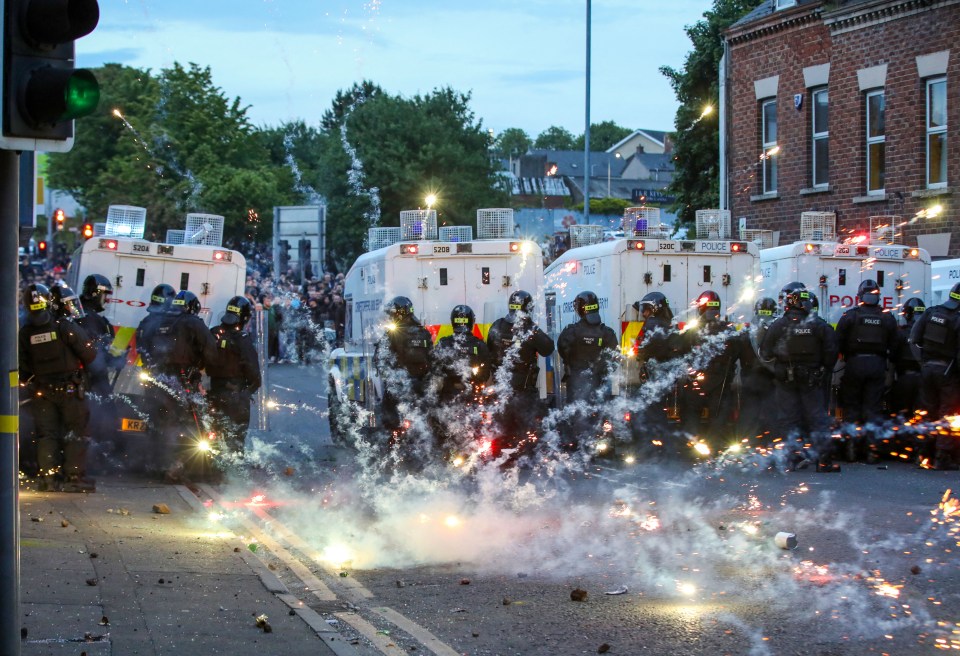 Riot police in Northern Ireland facing fireworks during anti-immigration demonstrations.
