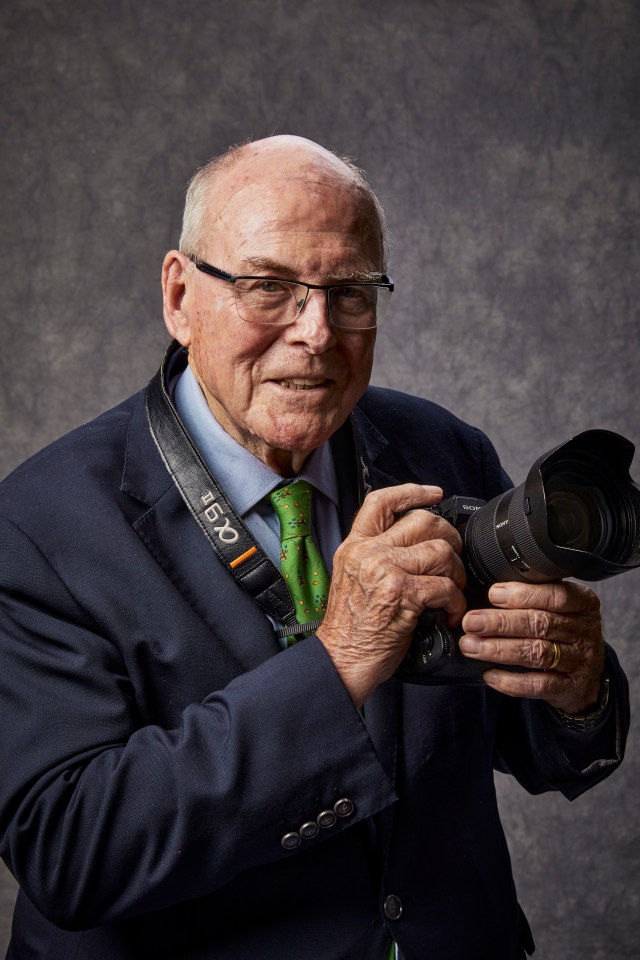 Portrait of Arthur Edwards holding a camera.