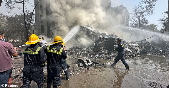 Rescue team members work as smoke rises at the site where an Air India plane crashed in Ahmedabad, India, June 12, 2025. REUTERS/Amit Dave
