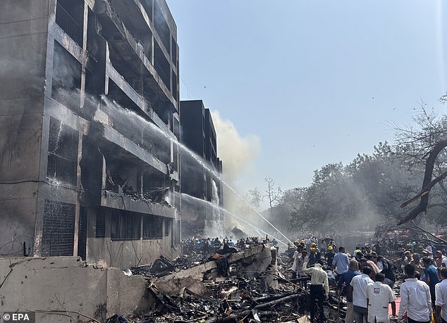 Firefighters work at the site of the crash near Sardar Vallabhbhai Patel International Airport