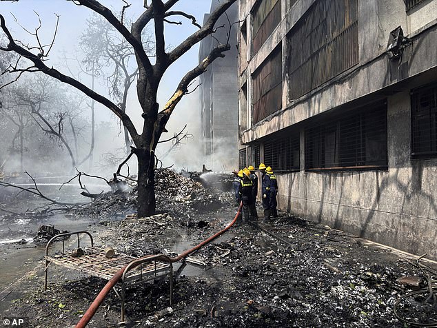 Firefighters work at the site of an airplane that crashed in India's northwestern city of Ahmedabad in Gujarat state, Thursday, June12, 202