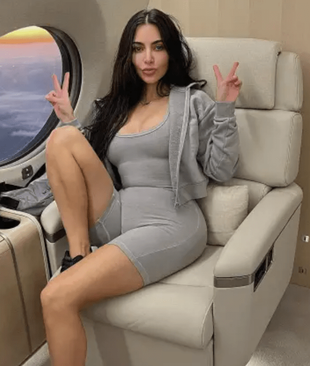 Kim Kardashian making peace signs while sitting on a private jet.