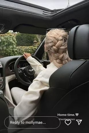 a woman is driving a car with a braided hairstyle .