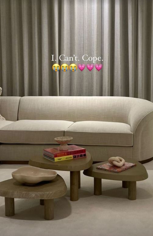 Beige sofa and three wooden side tables in a living room.