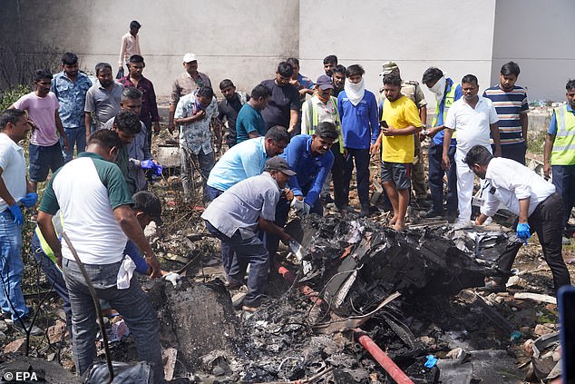 People work to move wreckage from the crash as they search for any survivors - the likelihood of which has dimmed by the hour