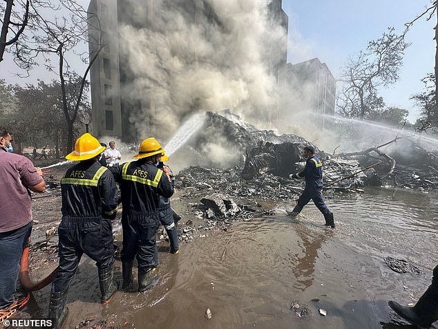 Rescue team members work as smoke rises at the site in Ahmedabad, India, June 12, 2025