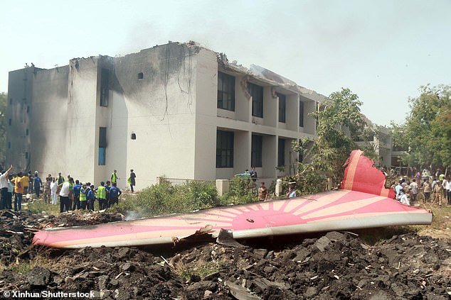 People look at the debris of an Air India plane crashed in Ahmedabad of India's Gujarat state