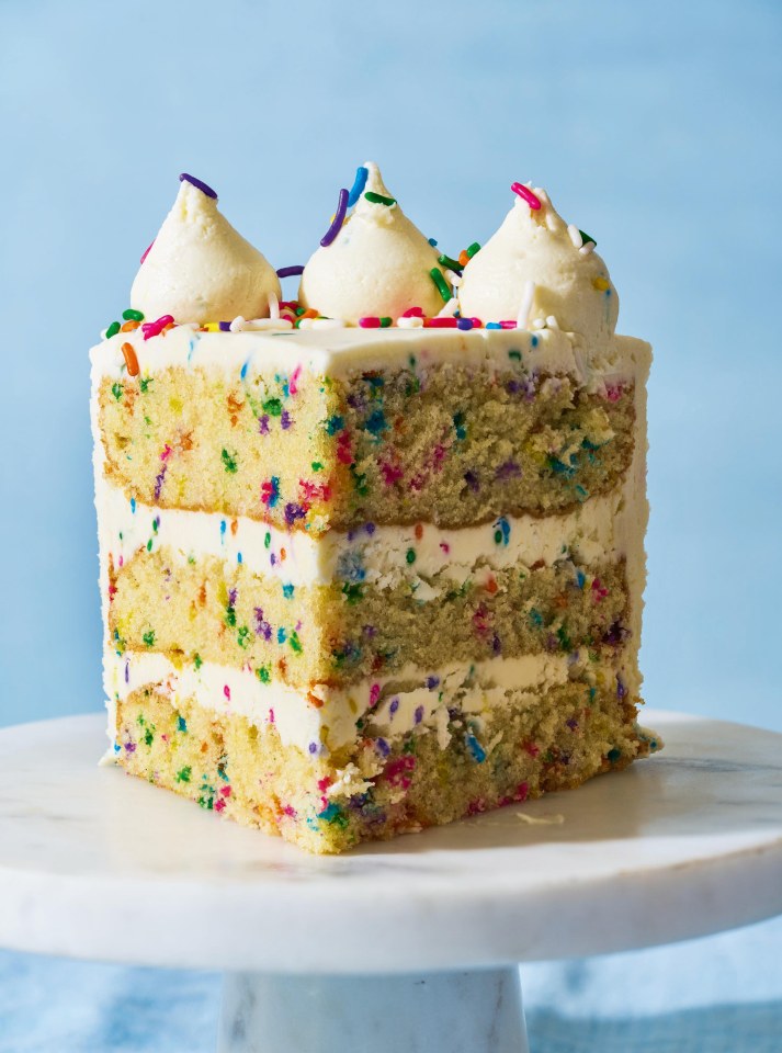 A slice of funfetti cake with vanilla frosting.