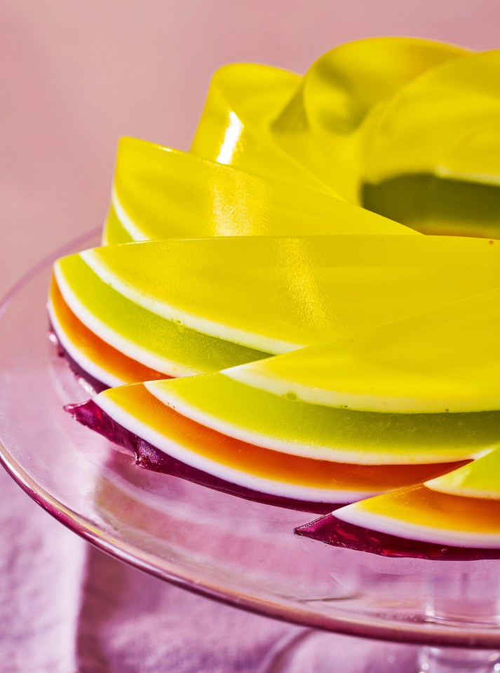 Layered rainbow jelly on a glass plate.