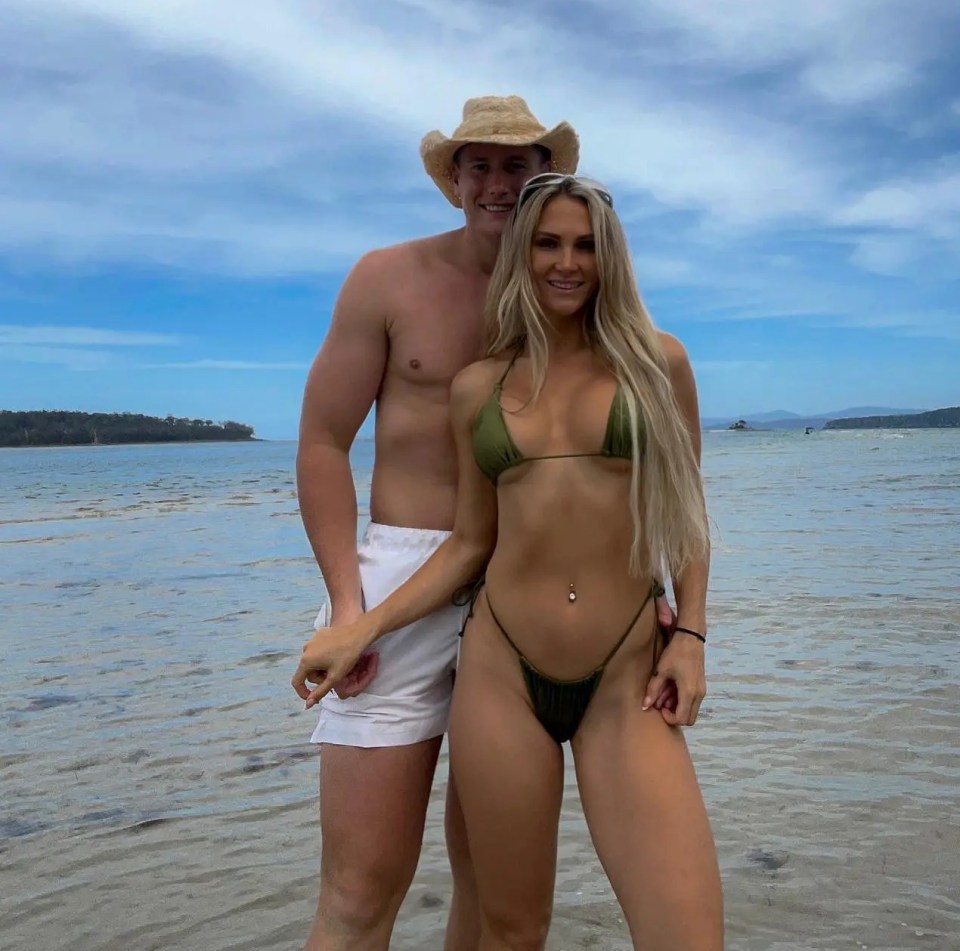 Couple holding hands on a beach.