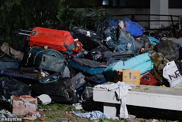 Passangers' luggage lies at the crash site after the plane, bound for London's Gatwick Airport, crashed during take-off from Ahmedabad Airport