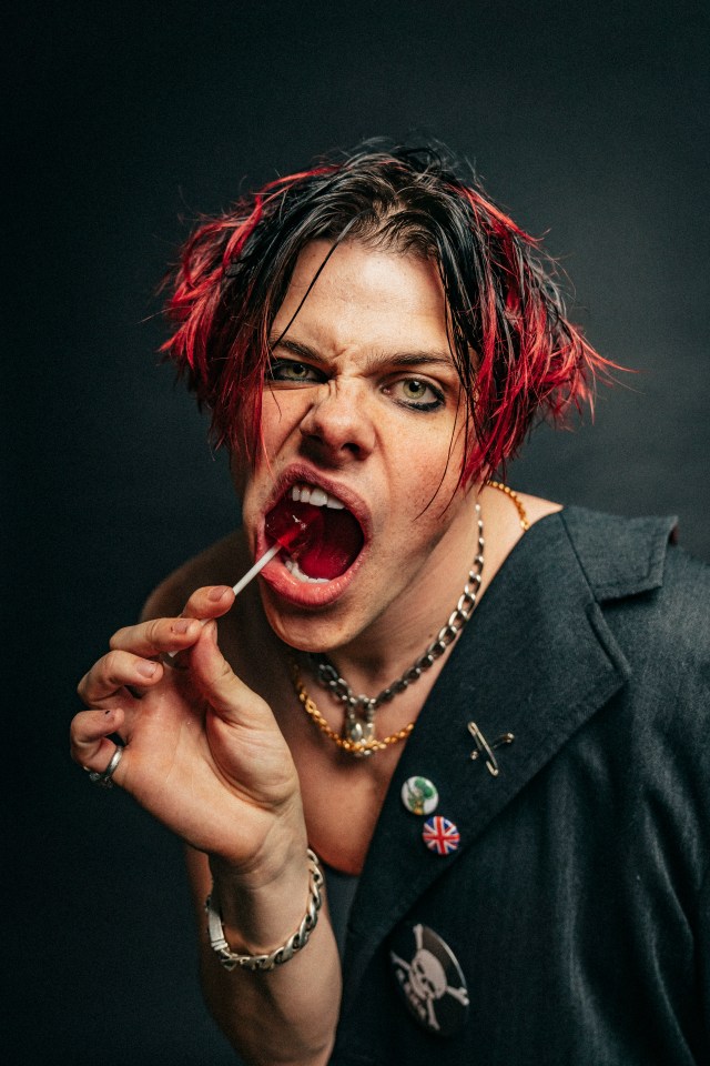 Portrait of Yungblud eating a lollipop.