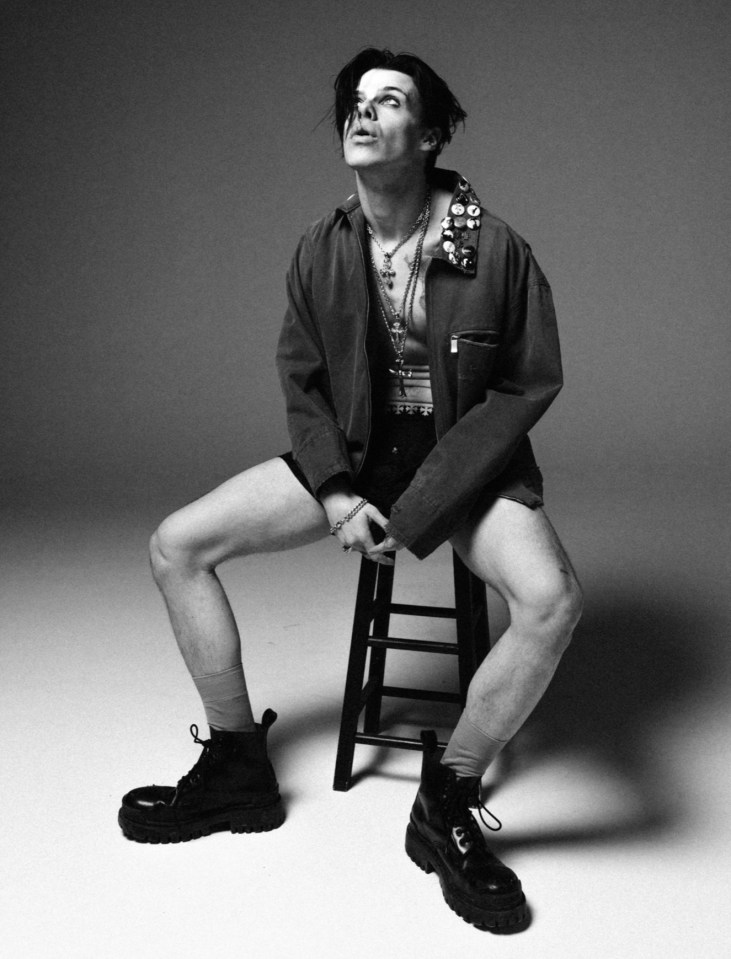Black and white photo of YUNGBLUD sitting on a stool.
