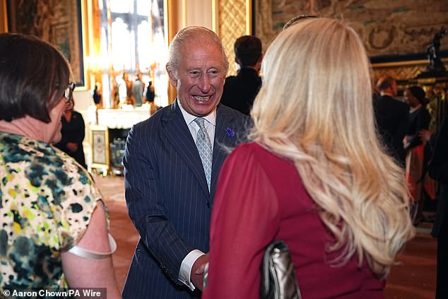 The King pictured speaking to chairs of the judging panel during tonight's reception at Windsor Castle
