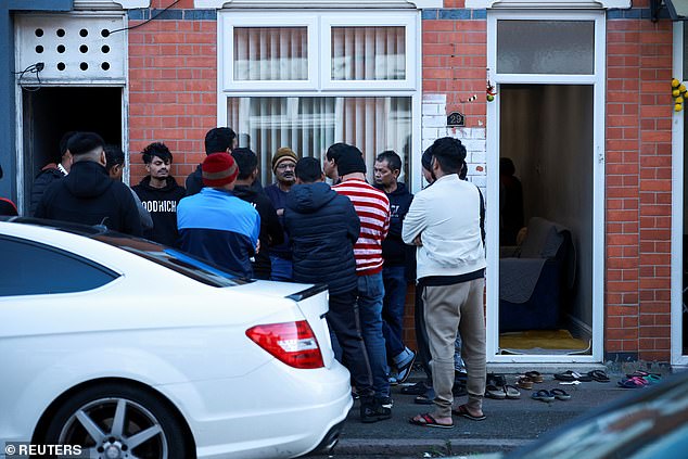 People stand outside the survivor's family home in Leicester on Thursday after news of the crash