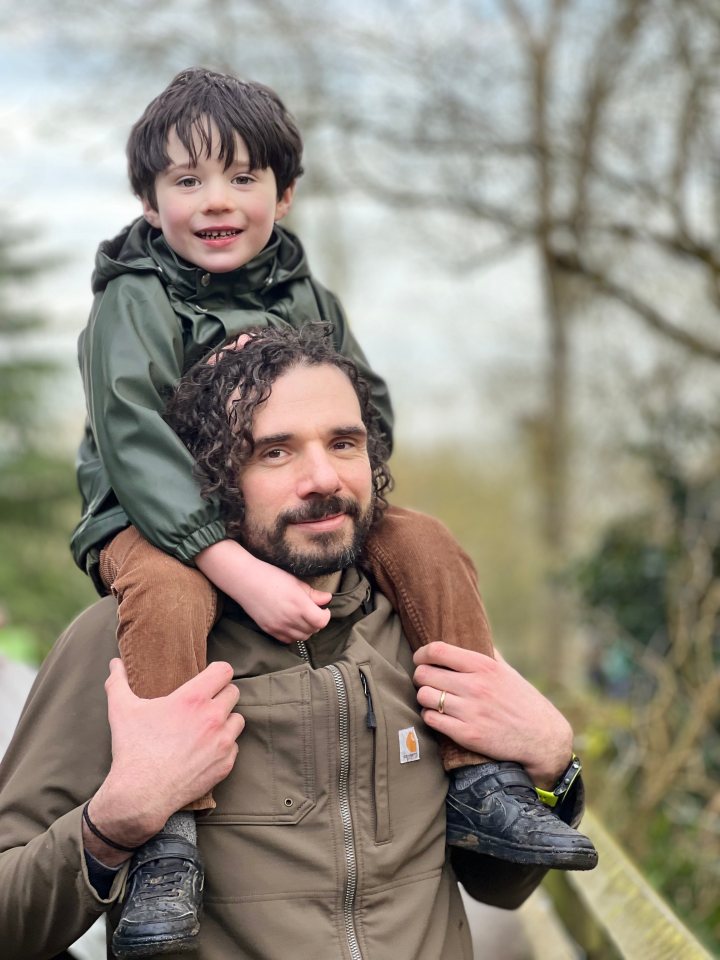 A man carrying a young boy on his shoulders.