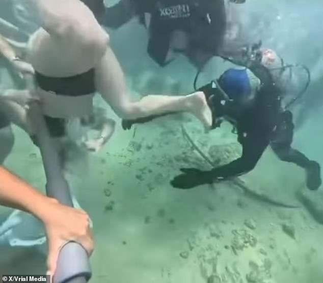 Divers rushed to help once the woman's helmet had fallen to the sand below