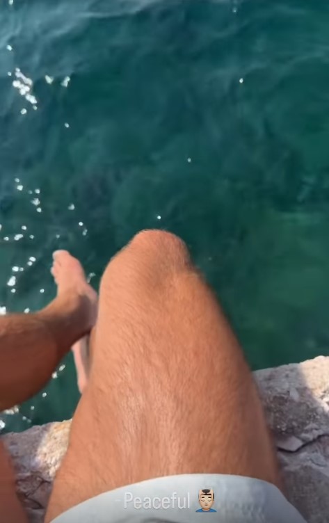 Person's legs by the water.