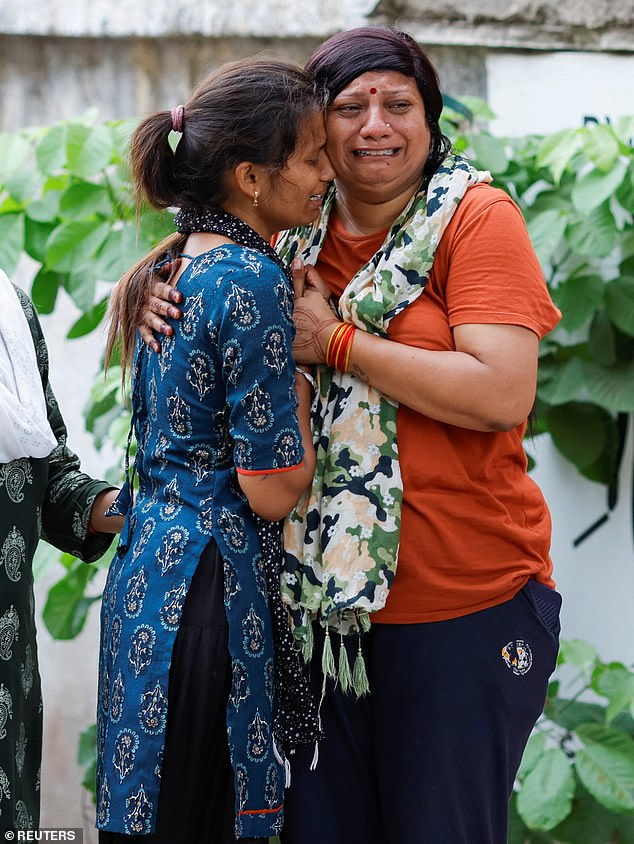 Officials said most of the bodies were charred beyond recognition. Pictured: Relatives of victims, who died in the plane crash
