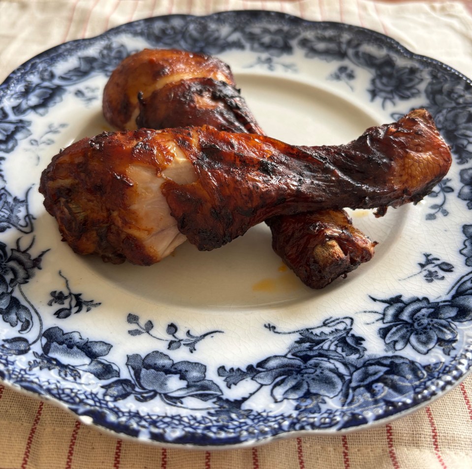 Two air-fried BBQ chicken legs on a plate.