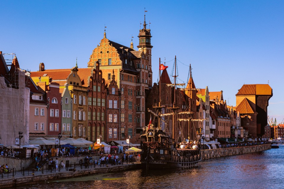 Gdansk's riverside with medieval buildings and a ship.