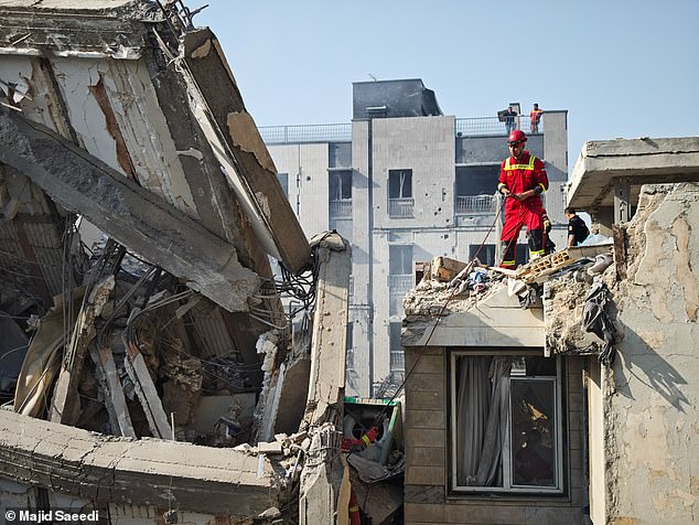 People look over damage to buildings following Israeli airstrikes on June 13, 2025 in Tehran, Iran