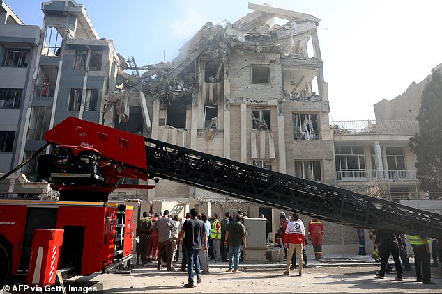 Rescue teams work outside a heavily damaged building, targeted by an Israeli strike in the Iranian capital Tehran on June 13, 2025