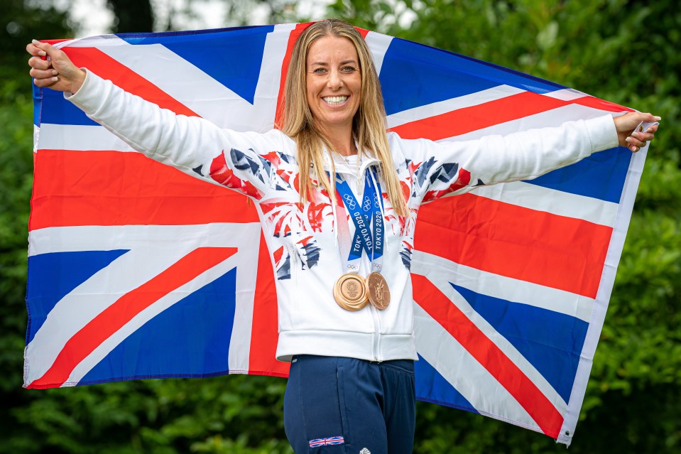 Charlotte Dujardin holding a UK flag and Olympic medals.