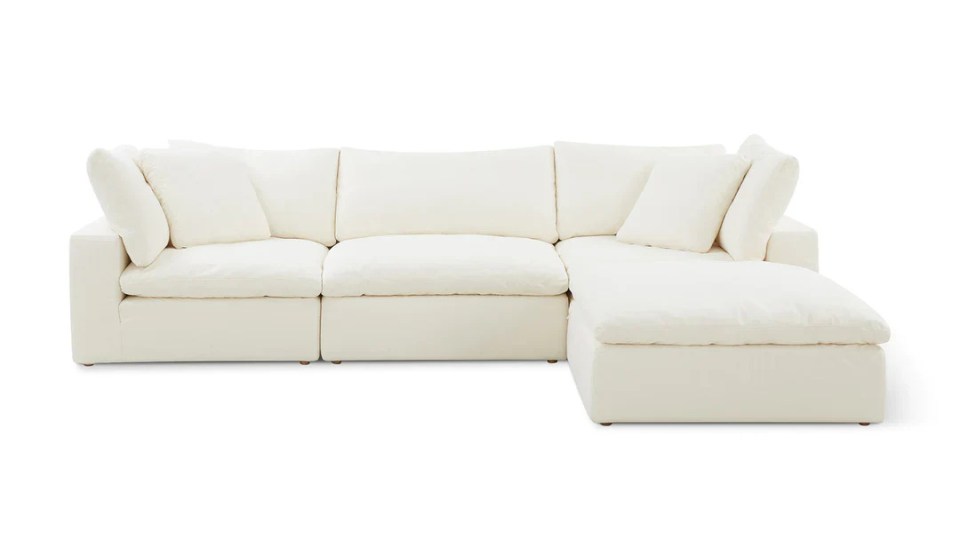 Off-white sectional sofa with pillows.