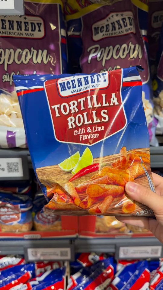 A hand holding a bag of McEnnedy tortilla rolls.