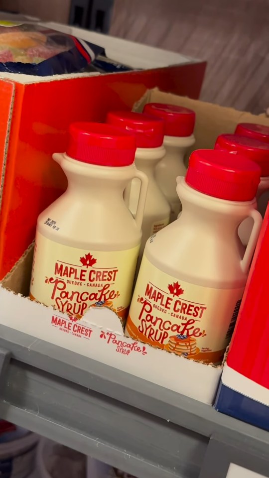 Several bottles of Maple Crest pancake syrup in a Lidl store.