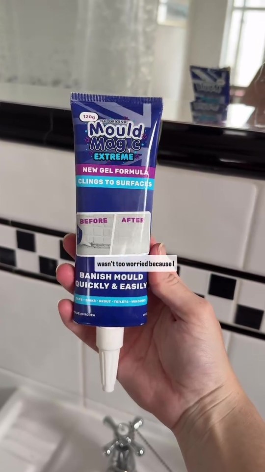 Hand holding tube of Mould Magic Extreme mold remover.