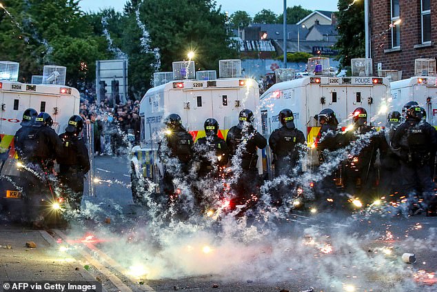 Fireworks thrown at Riot Police illluminate the road during a thrid night of anti-immigration demonstrations in Ballymena, Northern Ireland