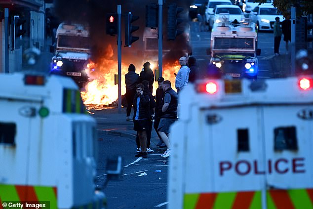 A fire is seen burning in Ballymena after rioters set objects alight in the street