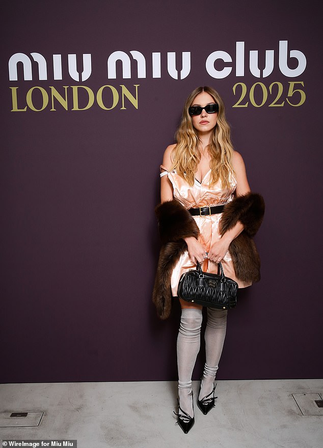 The actress, 27, put on a glamorous display in a pale pink satin mini dress, teamed with thigh-high grey socks and black pointed heels