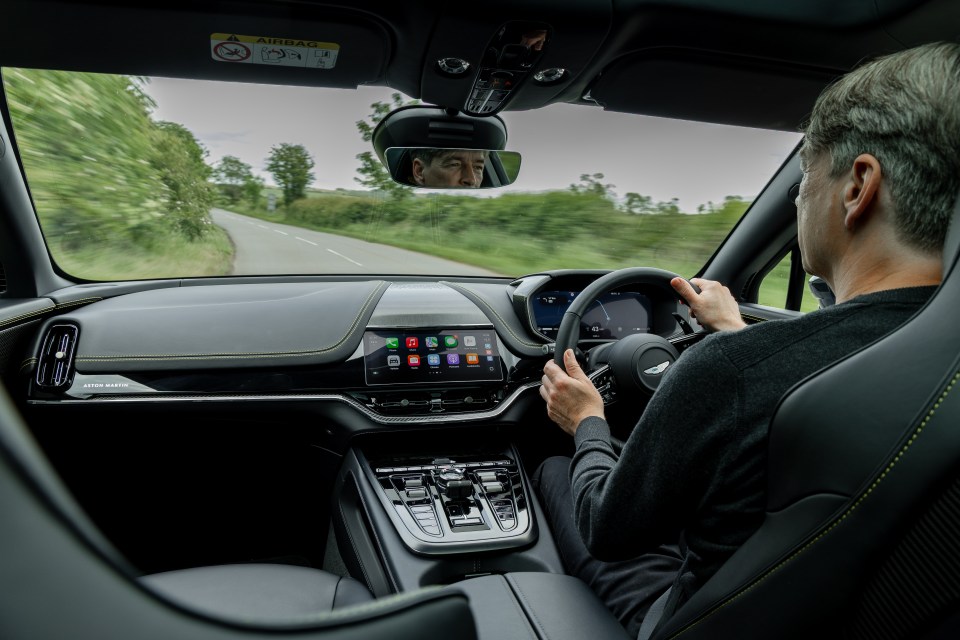 Person driving an Aston Martin.