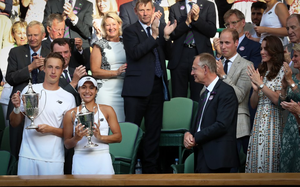 Heather Watson and Henri Kontinen holding mixed doubles trophies at Wimbledon.