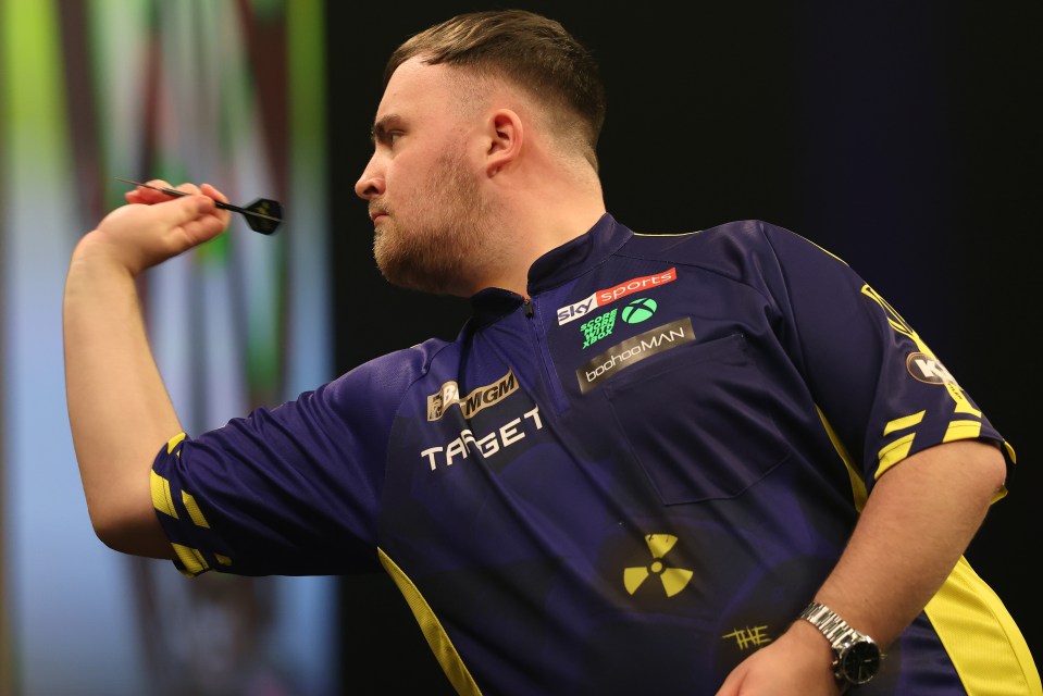 Luke Humphries holding the Premier League Darts trophy.
