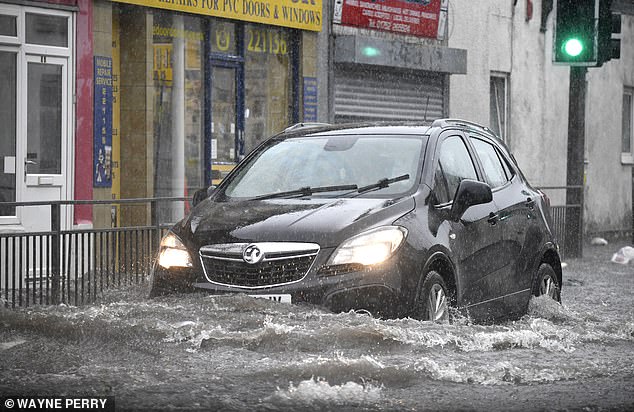 Thursday saw the first round of storms hitting Northern Ireland, South West England and Wales. Pictured: A car struggles through floodwater in Plymouth, Devon