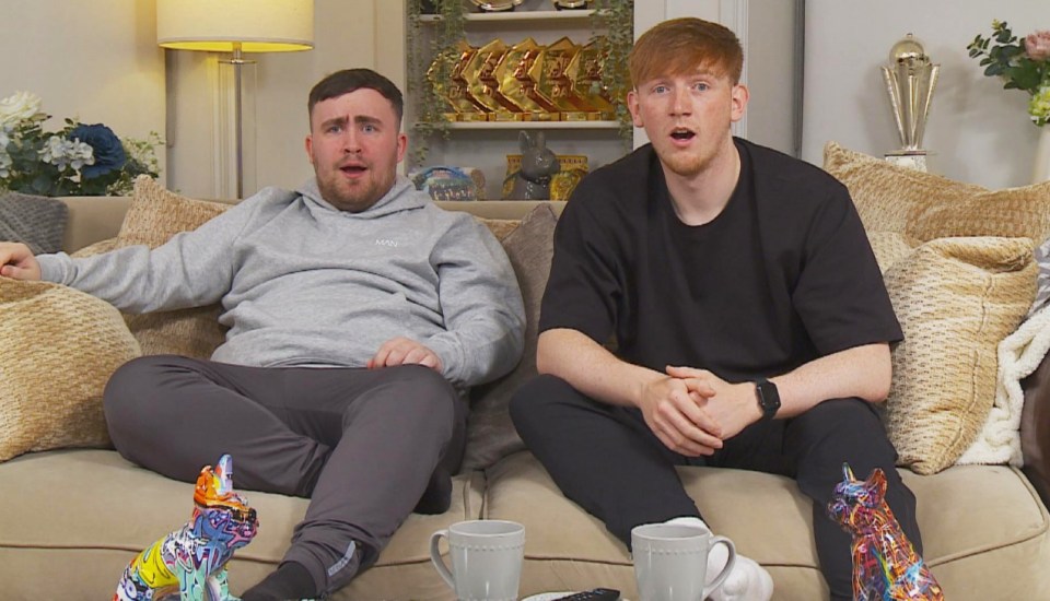 Two men sitting on a couch, announcing their participation in a reality TV show.